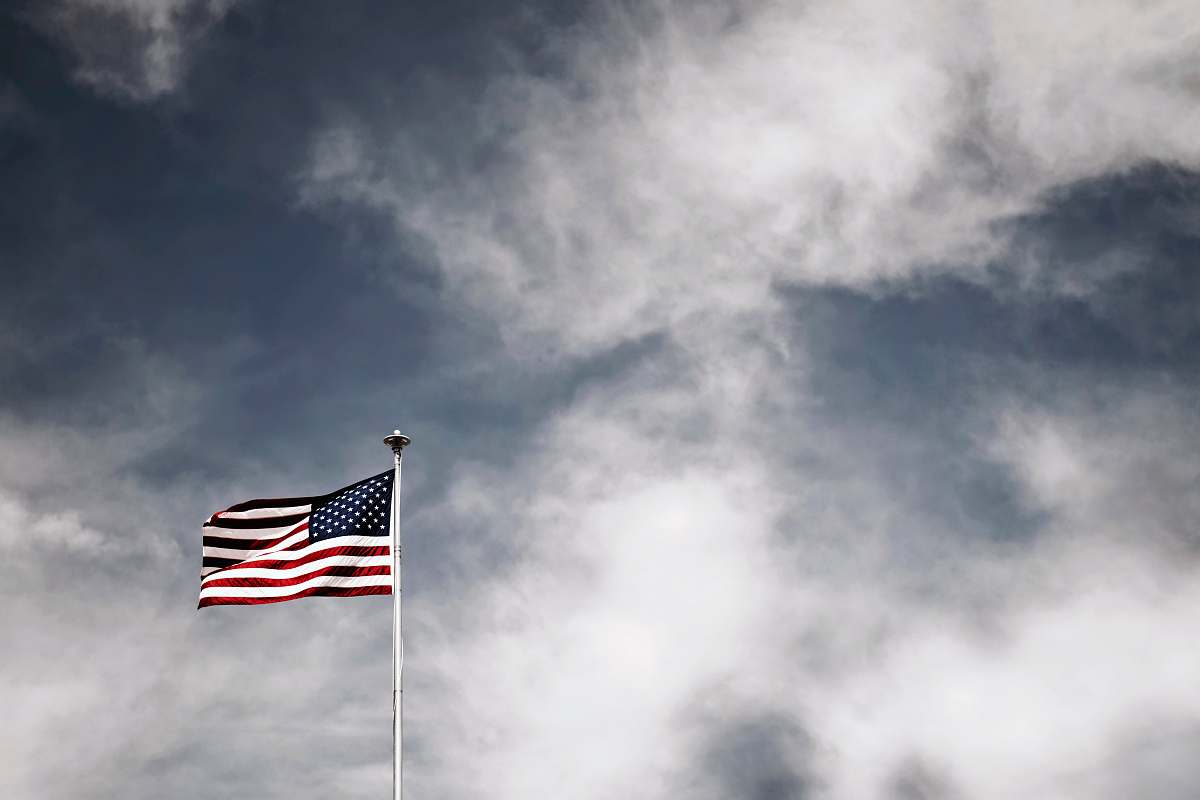 american flag waving USA flag under grey sky symbol